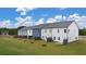 View of the back of townhomes that have a nice grass yard with newly planted trees and privacy panels at 1122 Edinberg Dr, Villa Rica, GA 30180