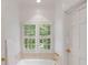 Bright bathroom with white cabinetry, a soaking tub, and shuttered windows with natural light at 130 River Ne Lndg, Sandy Springs, GA 30350