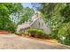 Charming gray home with a winding driveway, lush landscaping, and a glimpse of the lake at 130 River Ne Lndg, Sandy Springs, GA 30350