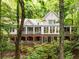 Charming two-story home with brick and light gray exterior, surrounded by lush green trees at 130 River Ne Lndg, Sandy Springs, GA 30350