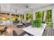 Relaxing screened porch with stylish furniture, a stone fireplace, ceiling fans, and serene wooded views at 130 River Ne Lndg, Sandy Springs, GA 30350