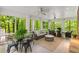 Enclosed porch with ceiling fans, wicker furniture, and views of the surrounding lush greenery and trees at 130 River Ne Lndg, Sandy Springs, GA 30350