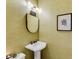 This powder room features stylish fixtures, textured wallpaper, and an elegant mirror and wall art at 130 River Ne Lndg, Sandy Springs, GA 30350