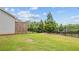 Backyard with lush green grass, fenced perimeter, and privacy trees for outdoor enjoyment at 4591 Grenadine Cir, Acworth, GA 30101
