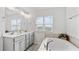 Bright bathroom featuring double vanity, sleek countertops, a soaking tub and large window at 4591 Grenadine Cir, Acworth, GA 30101