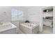 Relaxing bathroom with a tiled soaking tub, large window, and a walk-in closet at 4591 Grenadine Cir, Acworth, GA 30101