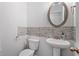Elegant powder room features a pedestal sink, decorative mirror, and brick accent wall at 4591 Grenadine Cir, Acworth, GA 30101