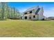 Back exterior of the house with covered patio and large backyard with tall trees at 4708 Cooling Water Sw Cir, Powder Springs, GA 30127
