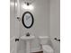 New half bathroom with round framed mirror and pedestal sink at 4708 Cooling Water Sw Cir, Powder Springs, GA 30127