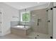 Bathroom featuring soaking tub, and tile and glass enclosed shower with a view to the outdoors at 4708 Cooling Water Sw Cir, Powder Springs, GA 30127