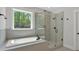 Bright bathroom featuring soaking tub, glass enclosed shower and large windows with a view to the outdoors at 4708 Cooling Water Sw Cir, Powder Springs, GA 30127