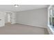 A spacious bedroom featuring plush carpeting, natural light from the window, and an adjacent room at 4708 Cooling Water Sw Cir, Powder Springs, GA 30127