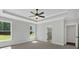 Bright bedroom with tray ceilings, a ceiling fan, large windows, and a view into the Primary bathroom with glass enclosed shower at 4708 Cooling Water Sw Cir, Powder Springs, GA 30127