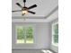 Bedroom featuring tray ceilings, ceiling fan, neutral color palette, carpet and large windows with scenic outdoors views at 4708 Cooling Water Sw Cir, Powder Springs, GA 30127