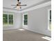 Spacious bedroom featuring tray ceilings, a ceiling fan, carpet floors and large windows that provide ample natural light at 4708 Cooling Water Sw Cir, Powder Springs, GA 30127