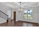 Bright dining room featuring hardwood floors, wainscoting, an elegant chandelier, and a large window with an open floorplan at 4708 Cooling Water Sw Cir, Powder Springs, GA 30127