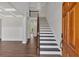 Bright open foyer with hardwood floors, a staircase with iron railings, and wainscoting panels at 4708 Cooling Water Sw Cir, Powder Springs, GA 30127