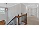 Hallway with wood and metal railing staircase, statement lighting, and neutral carpeted flooring at 4708 Cooling Water Sw Cir, Powder Springs, GA 30127