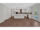 Bright kitchen with white cabinets, large island, stainless steel appliances, and wood flooring at 4708 Cooling Water Sw Cir, Powder Springs, GA 30127