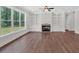 Bright living room features hardwood floors, built-in shelving, cabinets, fireplace, and a large window at 4708 Cooling Water Sw Cir, Powder Springs, GA 30127