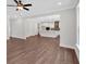 Open-concept living room and kitchen featuring wood floors, white trim, and ceiling fan at 4708 Cooling Water Sw Cir, Powder Springs, GA 30127