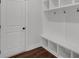 Bright mudroom complete with built-in shelving, hooks and a seating area with wood floors at 4708 Cooling Water Sw Cir, Powder Springs, GA 30127