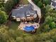 Overhead shot of an estate featuring a pool, patio, and landscaped gardens surrounded by mature trees at 670 Trinity Pl, Suwanee, GA 30024