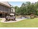 Expansive backyard with a pool, fire pit, and lush landscaping creates a serene outdoor space at 670 Trinity Pl, Suwanee, GA 30024