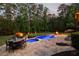 Backyard showcases a pool, patio with dining, lounge chairs, fire pit, and well-manicured lawn at 670 Trinity Pl, Suwanee, GA 30024