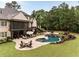 Spacious backyard features a pool, lounge seating, fire pit, and well-manicured lawn at 670 Trinity Pl, Suwanee, GA 30024
