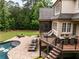 Elevated view of a backyard with a pool, patio, lounge chairs, and lush greenery, creating an inviting outdoor space at 670 Trinity Pl, Suwanee, GA 30024