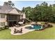 Aerial view of the backyard with a custom pool, patio, fire pit, and lush landscaping at 670 Trinity Pl, Suwanee, GA 30024