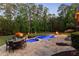 Backyard view of an in-ground pool, hot tub, fire pit, patio furniture, and manicured landscaping at 670 Trinity Pl, Suwanee, GA 30024