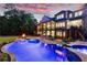 Beautifully lit backyard with a large pool, patio, and fire pit, creating a captivating nighttime ambiance at 670 Trinity Pl, Suwanee, GA 30024