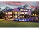 Twilight backyard scene with a sparkling pool, fire pit, and manicured landscaping, creating a tranquil retreat at 670 Trinity Pl, Suwanee, GA 30024