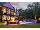 Twilight backyard view features a pool, fire pit, and outdoor seating, ideal for evening gatherings at 670 Trinity Pl, Suwanee, GA 30024