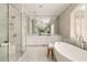 This bathroom features a soaking tub, a shower, marble floors, and a large vanity with mirrors and pendant lights at 670 Trinity Pl, Suwanee, GA 30024