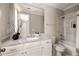 Bright bathroom featuring a white vanity with marble countertop and a tub with marble-look tiled walls at 670 Trinity Pl, Suwanee, GA 30024