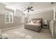 Bright bedroom with a tufted headboard, two windows, and plush carpet at 670 Trinity Pl, Suwanee, GA 30024