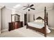 Bedroom with a decorative wooden four-poster bed, complemented by a large mirror and dresser at 670 Trinity Pl, Suwanee, GA 30024