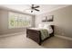 Comfortable bedroom featuring large window with plantation shutters and a dark wood frame bed at 670 Trinity Pl, Suwanee, GA 30024