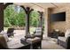 Stylish covered patio with stone accents, outdoor seating, and a clear view of the lush greenery at 670 Trinity Pl, Suwanee, GA 30024