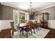 Formal dining room with a chandelier, elegant wallpaper, and a large table perfect for hosting dinner parties at 670 Trinity Pl, Suwanee, GA 30024