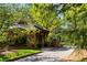 Charming stone gatehouse entrance with meticulous landscaping and a paver driveway at 670 Trinity Pl, Suwanee, GA 30024