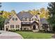 Grand stone and brick home with manicured front yard and charming architectural details at 670 Trinity Pl, Suwanee, GA 30024