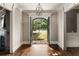 Elegant foyer featuring hardwood floors, chandelier, and view of the front yard through custom doors at 670 Trinity Pl, Suwanee, GA 30024