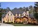 Stunning brick home featuring a beautifully landscaped front yard, elegant entrance, and meticulously maintained architecture at 670 Trinity Pl, Suwanee, GA 30024