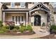 Charming stone home exterior with covered front porch and manicured landscaping at 670 Trinity Pl, Suwanee, GA 30024