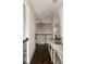 Hallway with hardwood floors, a decorative mirror, and view of staircase at 670 Trinity Pl, Suwanee, GA 30024