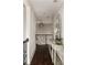 The upstairs hallway has hardwood floors, neutral walls, decorative console table and a view of the staircase at 670 Trinity Pl, Suwanee, GA 30024